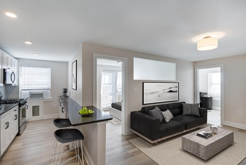 a living room and kitchen with a couch and a table